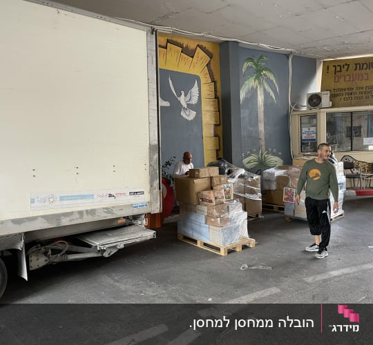 משאית חונה, אנשים מעבירים קופסאות על משטחים